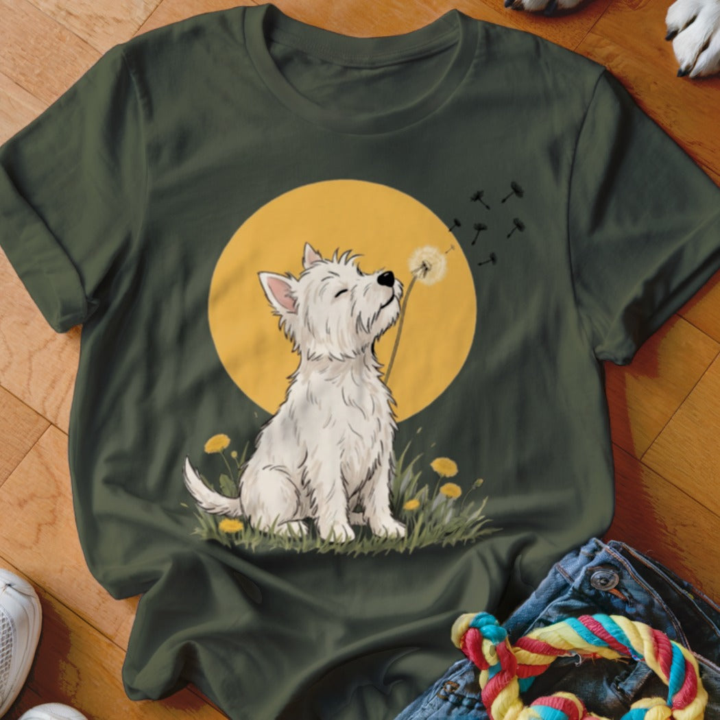 Dark green t-shirt featuring an illustration of a white Westie dog blowing dandelion seeds against a yellow sun.