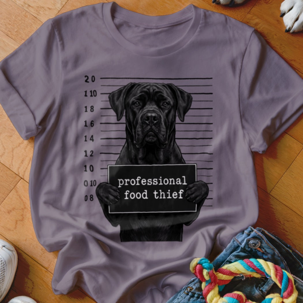Black dog mugshot on t-shirt reads "professional food thief"