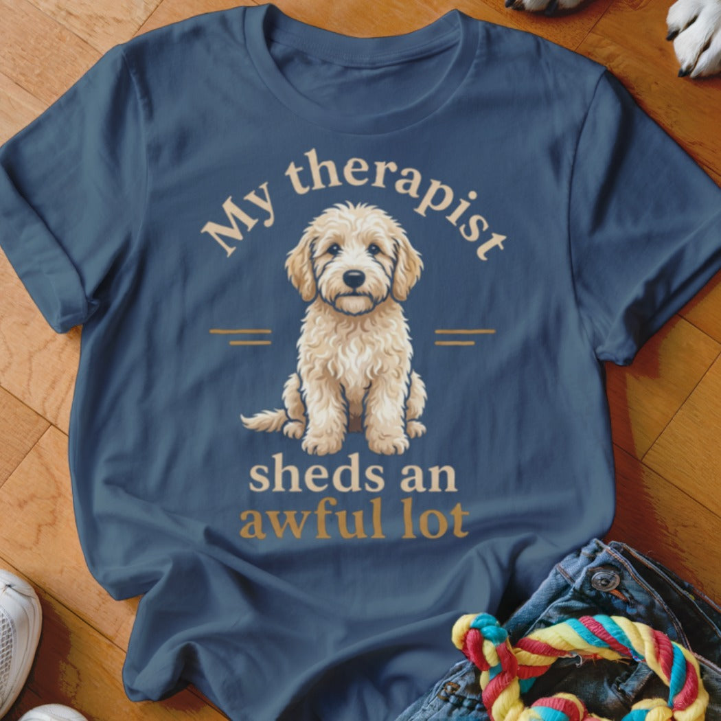 Blue t-shirt with text "My therapist sheds an awful lot" and a golden retriever puppy.