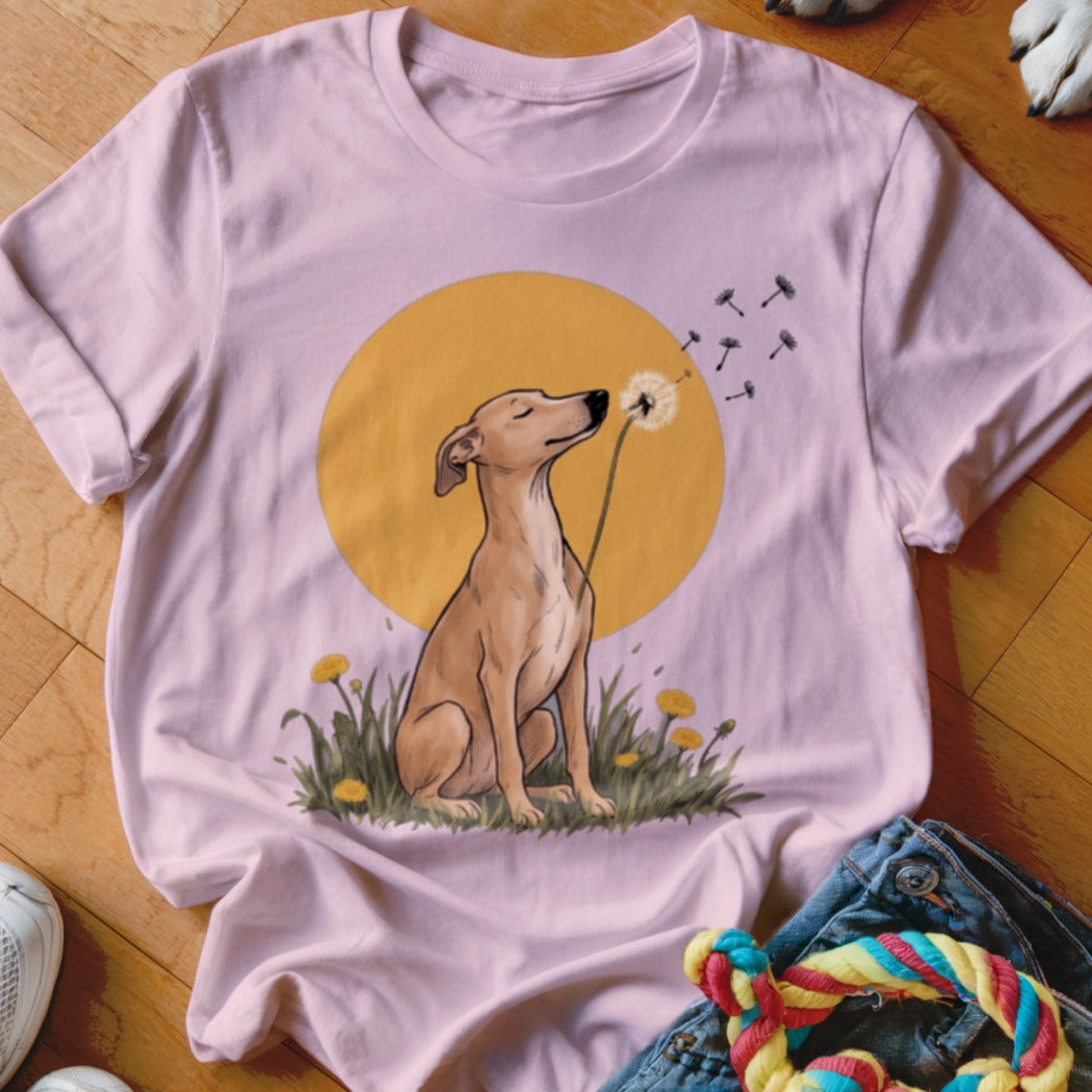 Pink t-shirt with a graphic of a brown dog blowing dandelion seeds against a yellow sun.