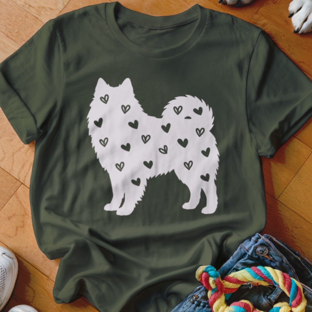 Green t-shirt with white silhouette of a dog covered in black hearts.