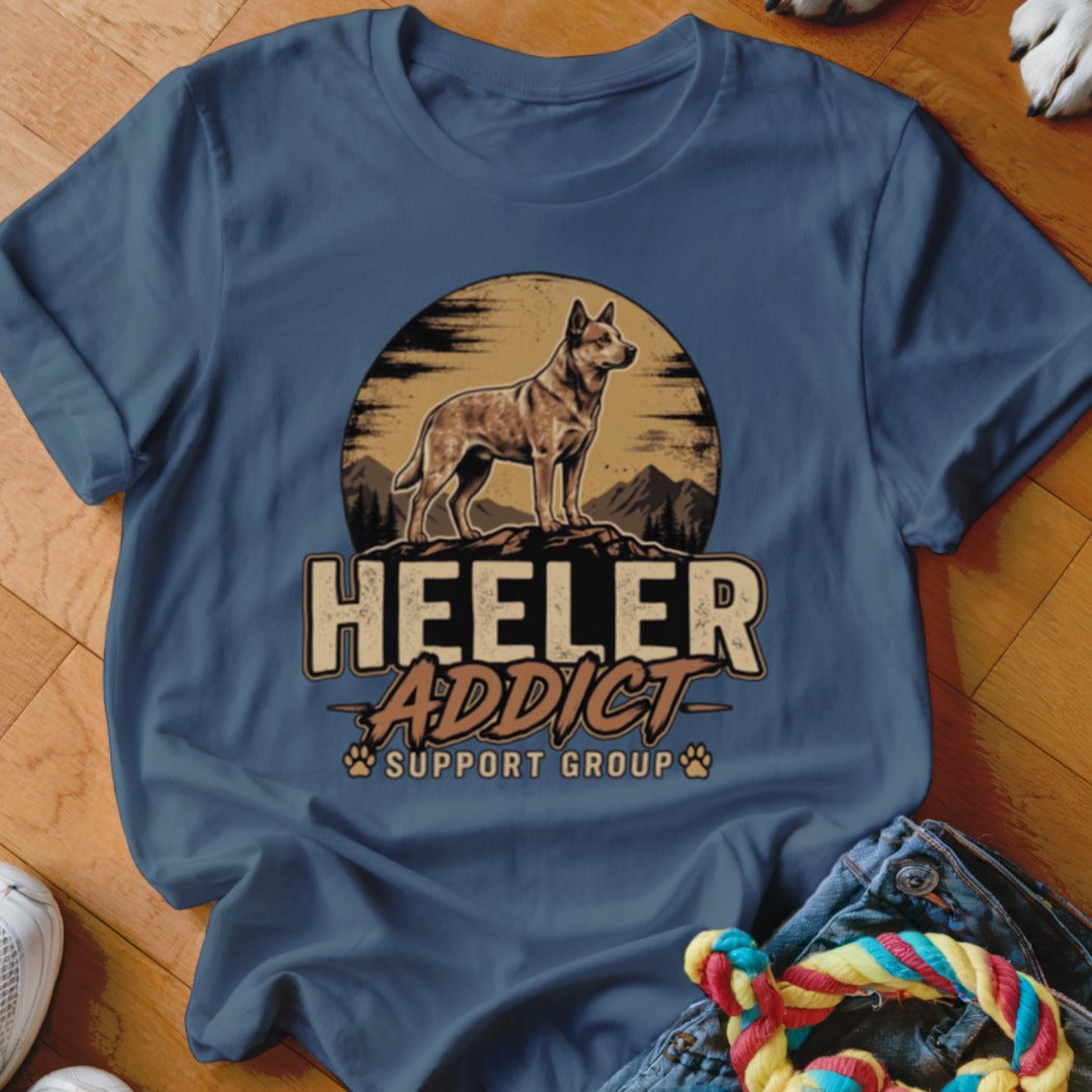 A blue t-shirt printed with a vintage-style graphic of an Australian Cattle Dog and the text Heeler Addict Support Group.