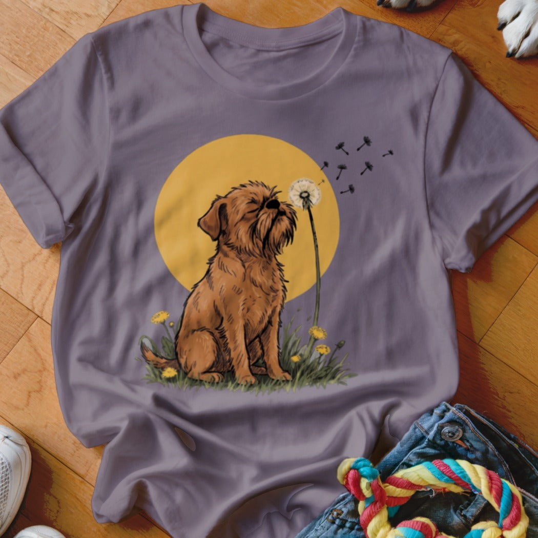 A grey t-shirt featuring an illustration of a brown dog blowing dandelion seeds against a yellow circle background.