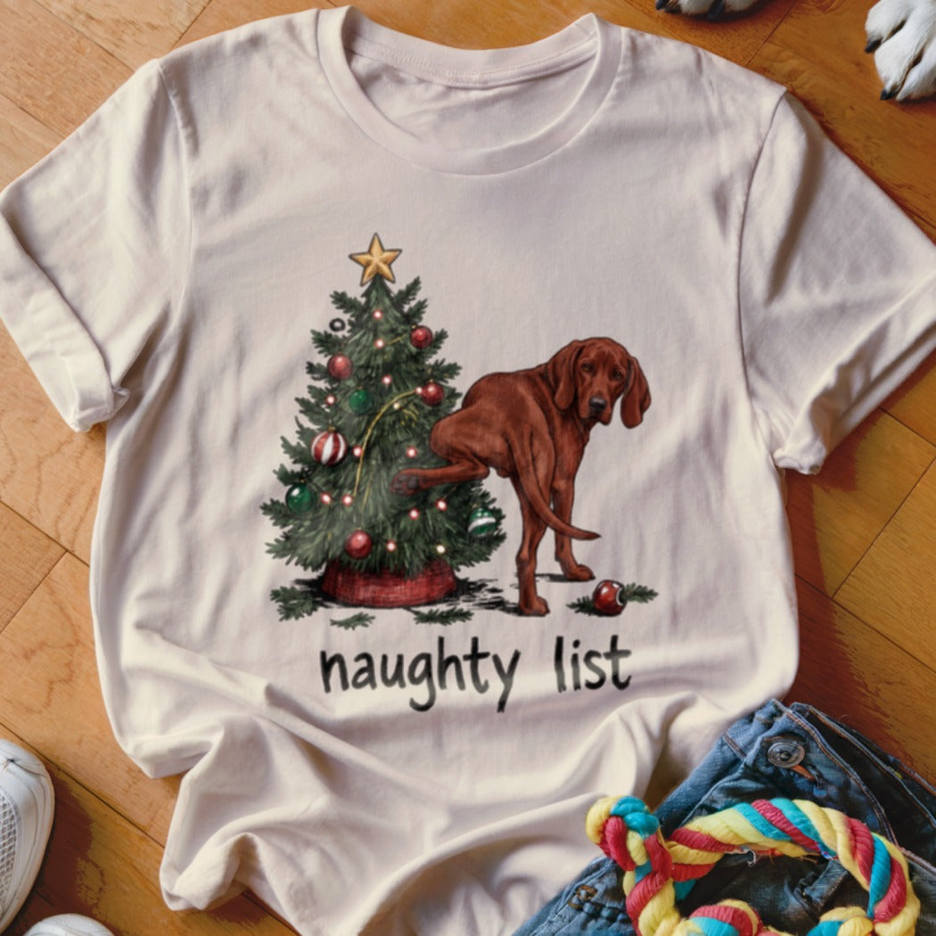 Brown dog lifting leg on Christmas tree with text "naughty list".