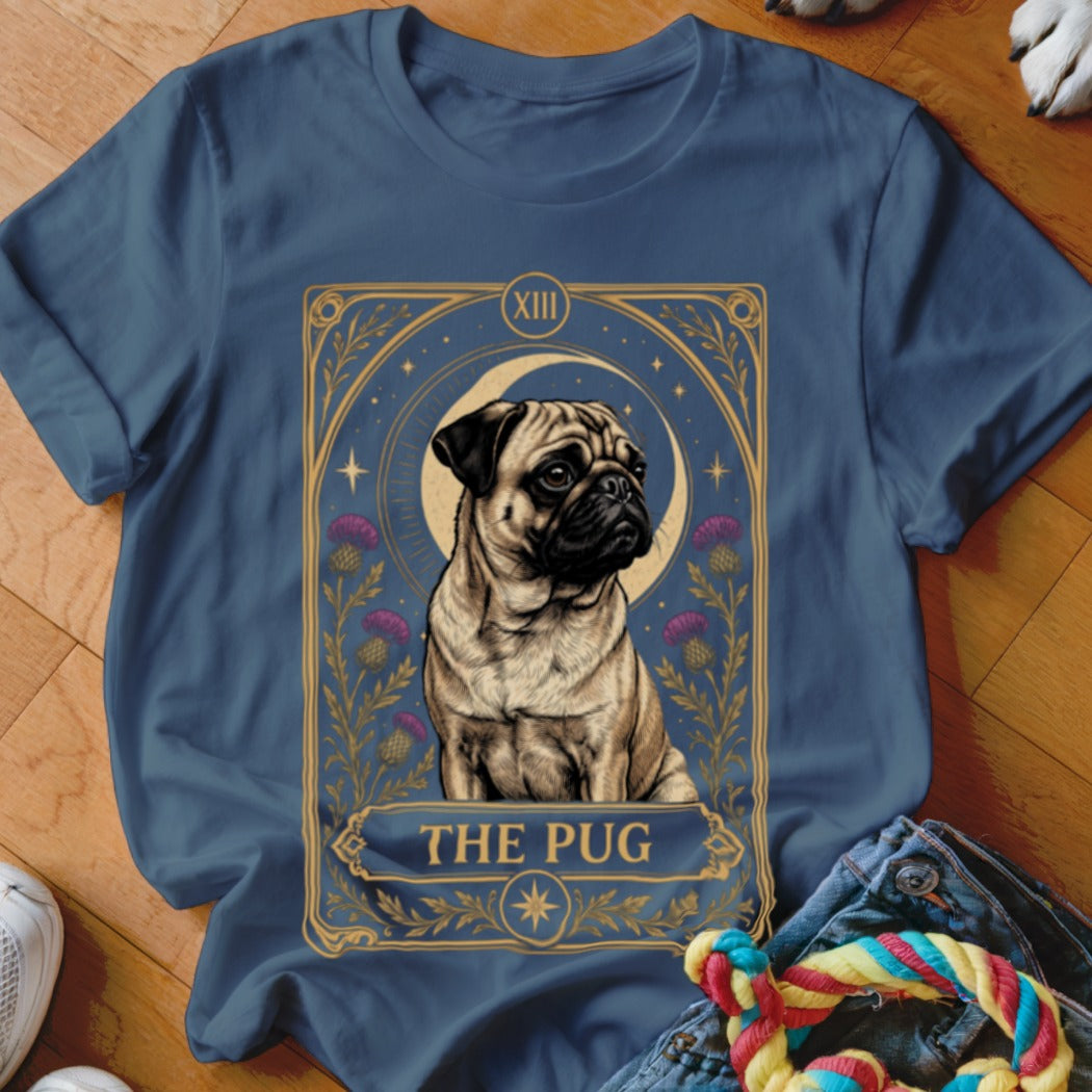 A blue t-shirt featuring a tarot card graphic with a pug, moon, and thistles.