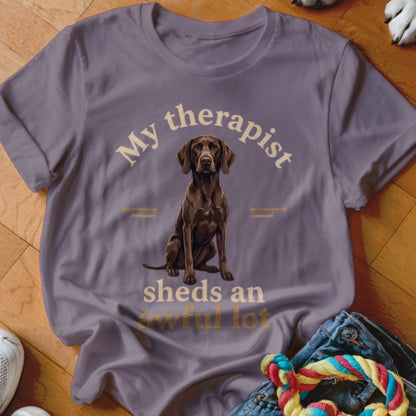 Purple t-shirt with a seated brown dog and text "My therapist sheds an awful lot."