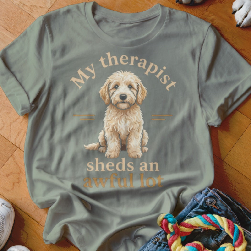 Light green t-shirt with text "My therapist sheds an awful lot" and a fluffy dog illustration.