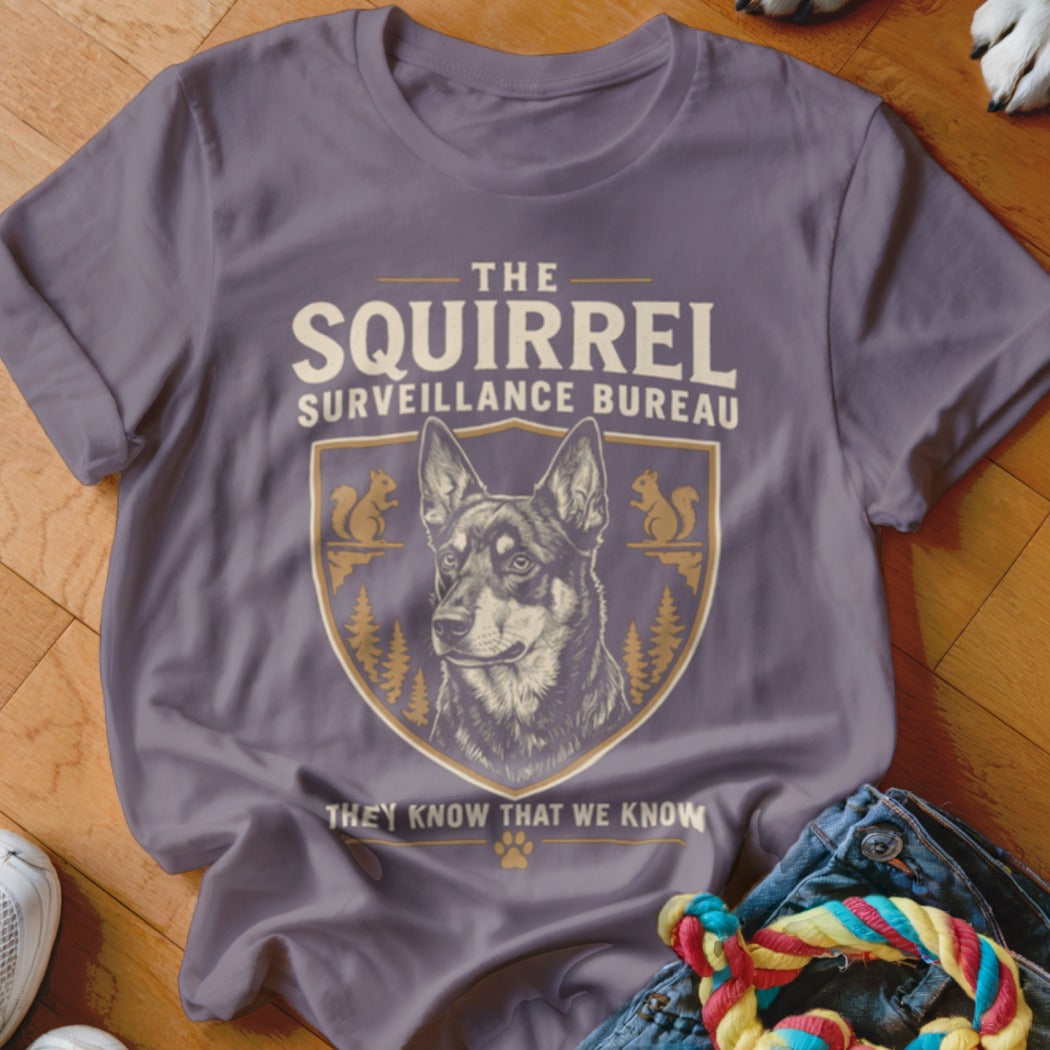 A gray crewneck t-shirt featuring a squirrel surveillance bureau graphic with a German Shepherd.