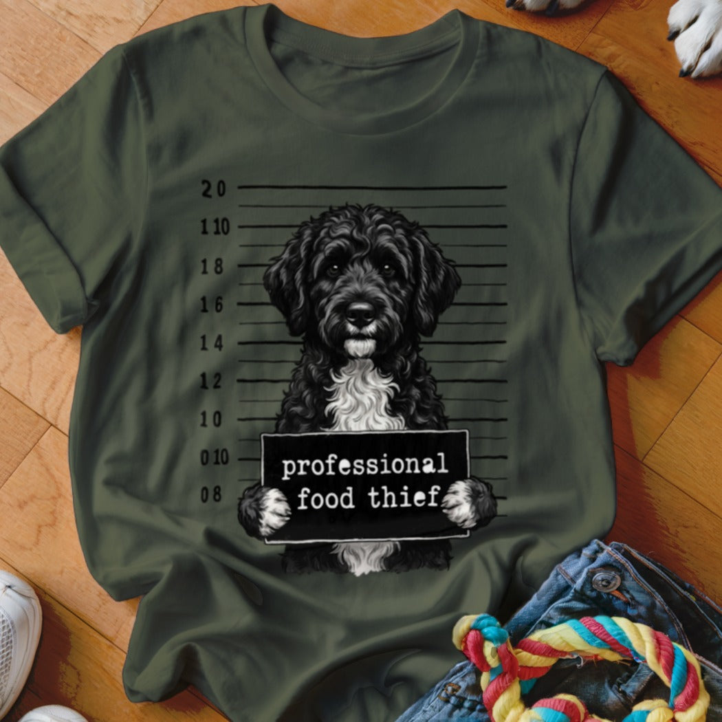 Black doodle dog mugshot with text "professional food thief".