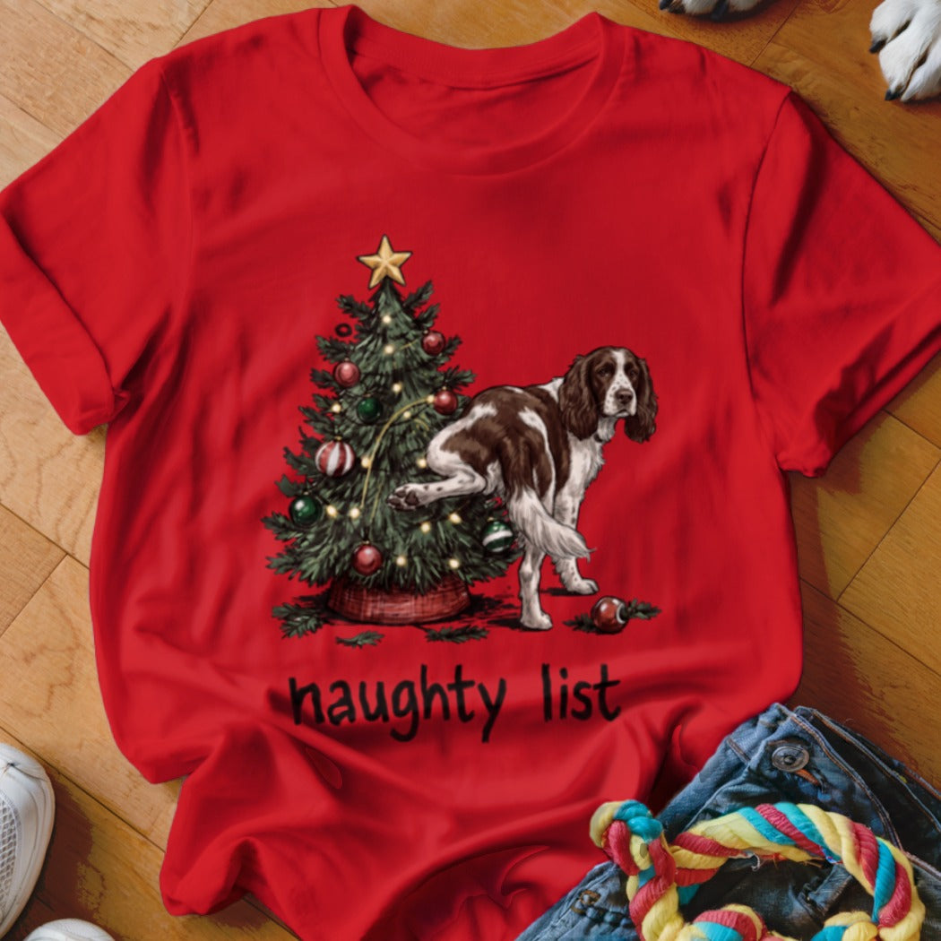 Brown and white dog peeing on Christmas tree with text "naughty list".