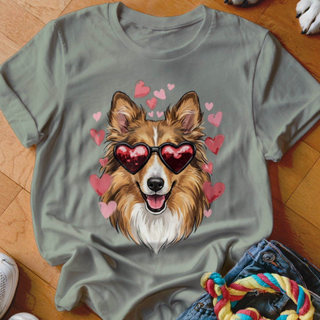 Sage green t-shirt featuring a graphic of a brown and white dog wearing heart-shaped sunglasses, surrounded by pink hearts.