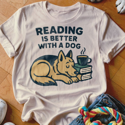 White t-shirt with "Reading is Better With a Dog" and illustration of dog sleeping on books with coffee.