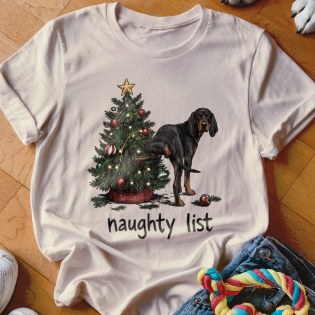 Black and tan dog pees on Christmas tree with "naughty list" text.