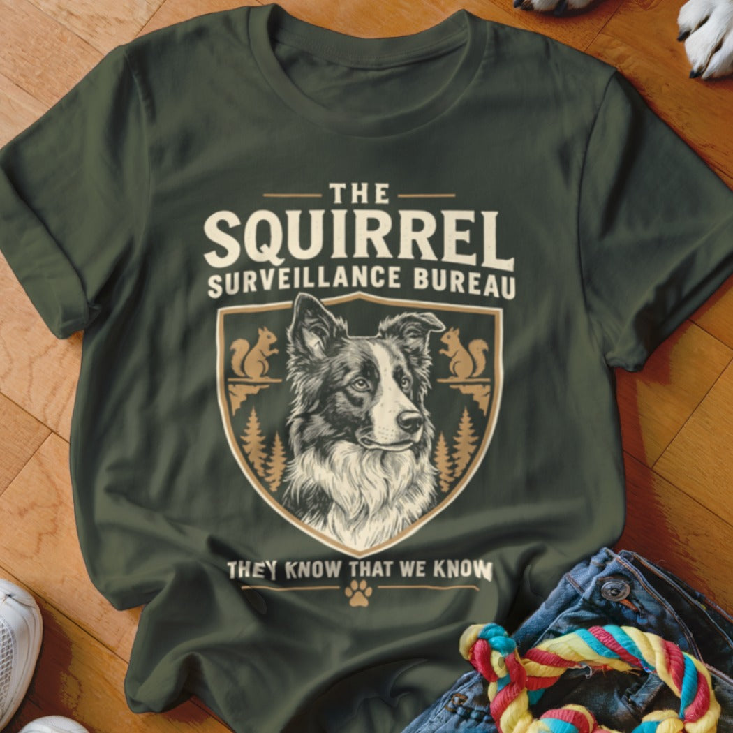 Dark green t-shirt featuring a graphic with a border collie and text reading The Squirrel Surveillance Bureau.