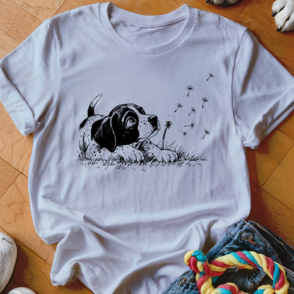 White crewneck t-shirt featuring a black ink illustration of a puppy watching floating dandelion seeds.