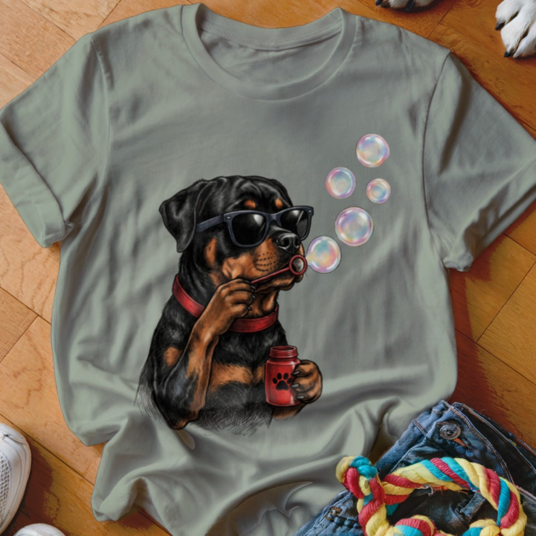 Sage green t-shirt featuring a graphic of a Rottweiler wearing sunglasses and blowing bubbles.