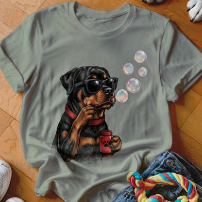 Sage green t-shirt featuring a graphic of a Rottweiler wearing sunglasses and blowing bubbles.