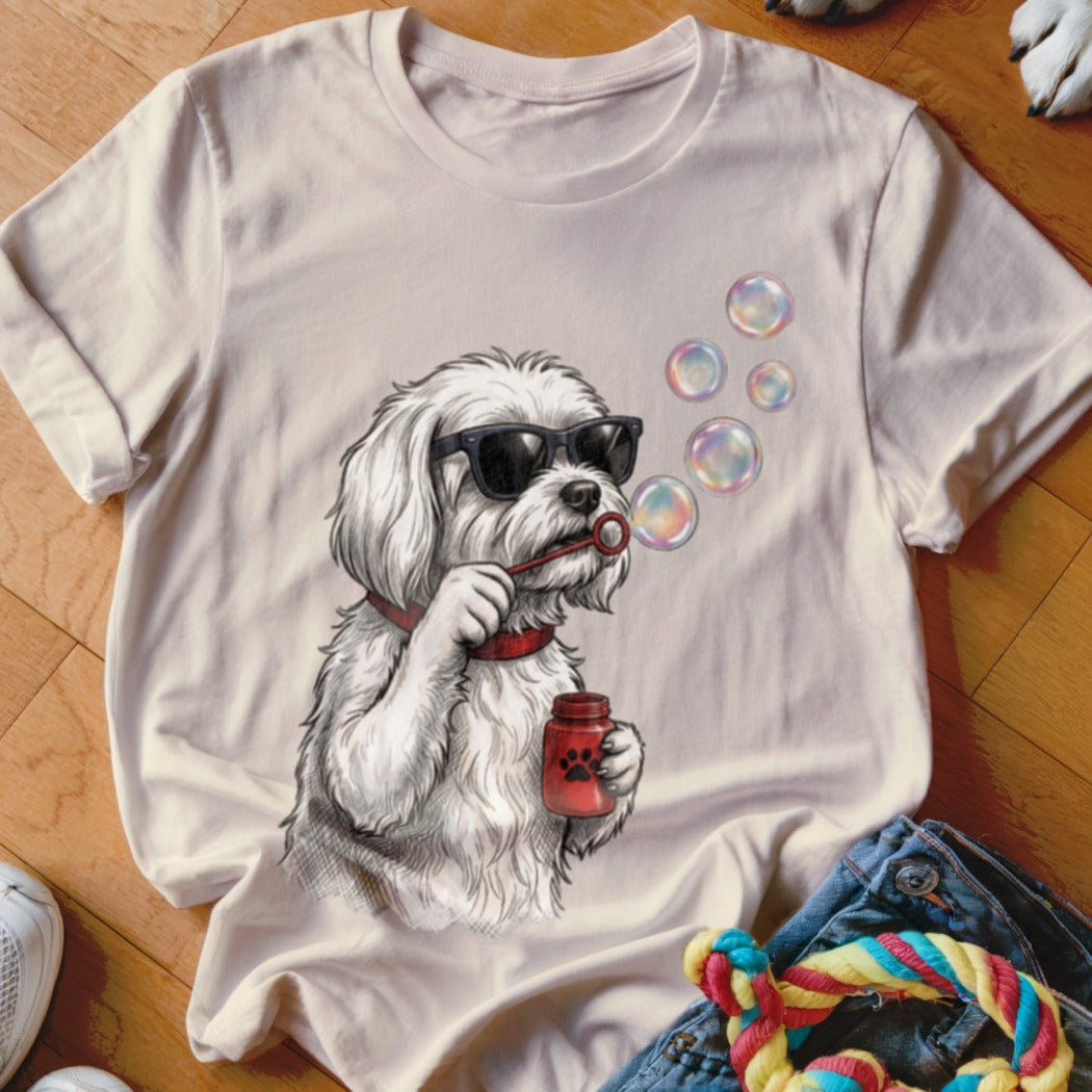 Beige crewneck t-shirt featuring an illustration of a white dog blowing bubbles wearing sunglasses.