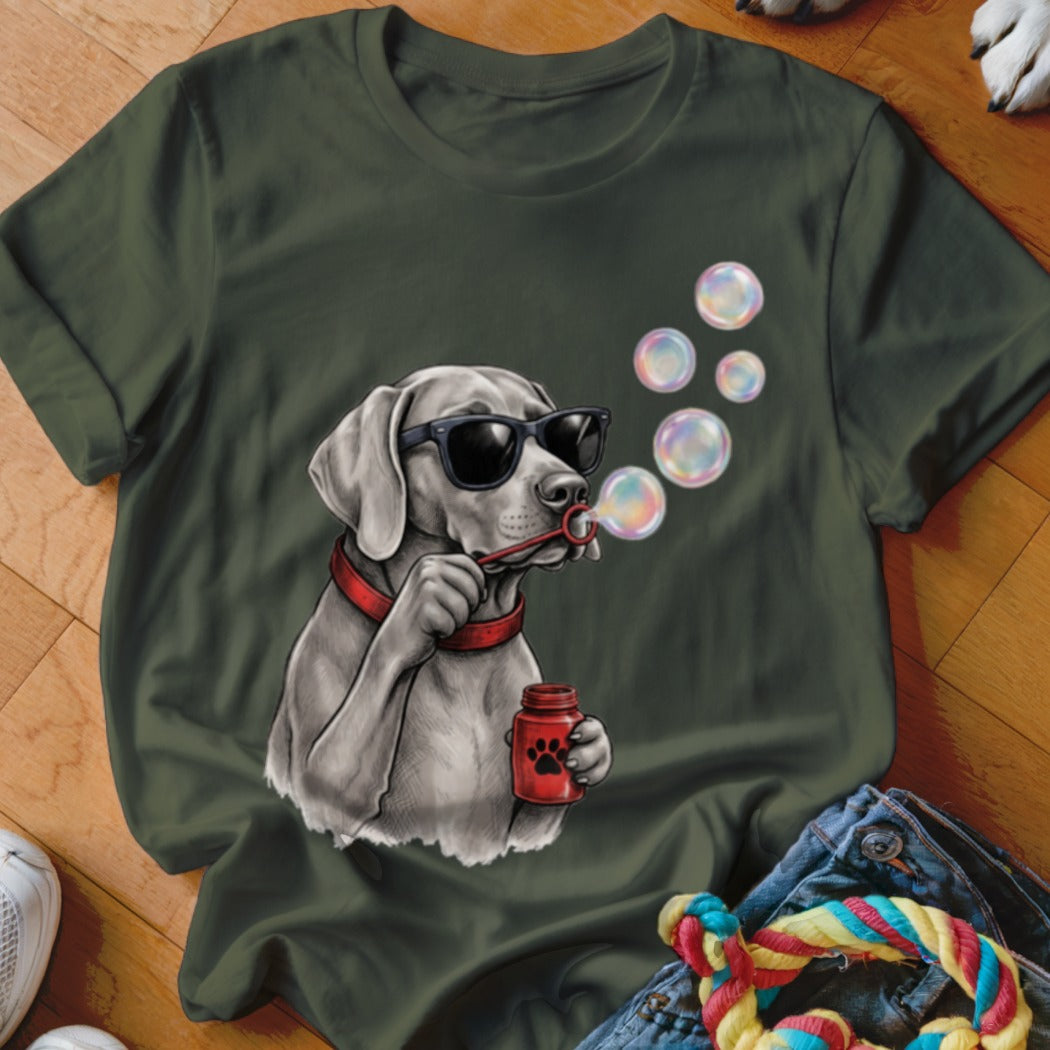 An olive green t-shirt featuring a graphic of a dog wearing sunglasses and blowing bubbles.