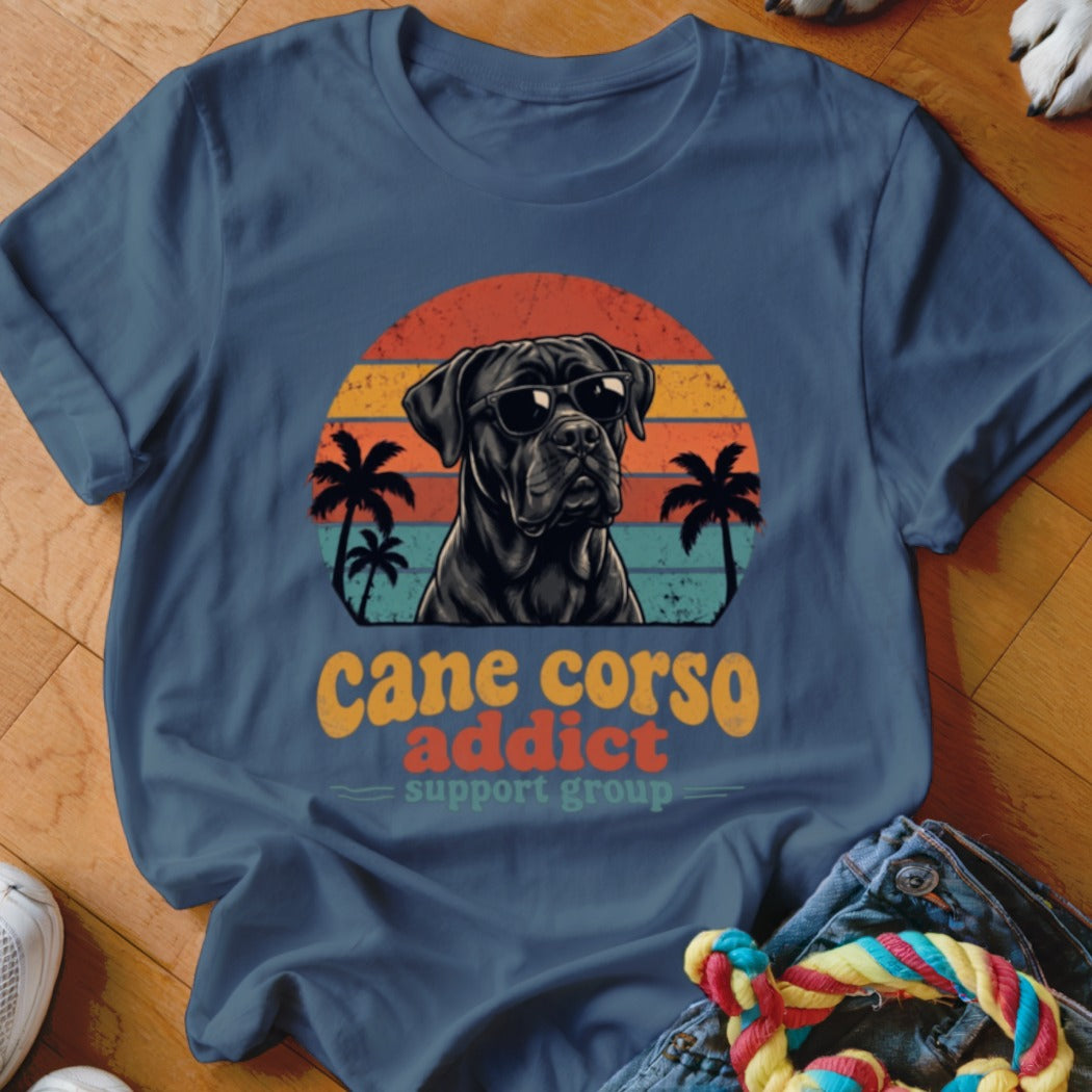 A blue t-shirt featuring a retro graphic of a Cane Corso wearing sunglasses and palm trees.