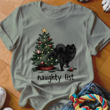 Black Pomeranian dog near Christmas tree with "naughty list" text.