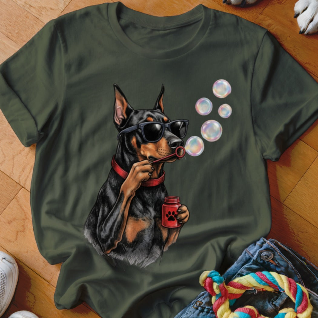 Olive green t-shirt featuring a Doberman wearing sunglasses and blowing soap bubbles.