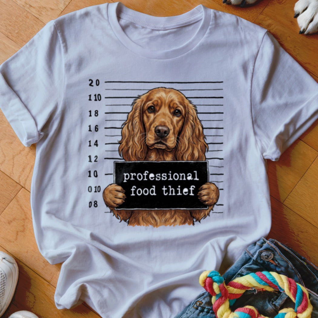 Brown dog mugshot graphic with text "professional food thief" on a white t-shirt.