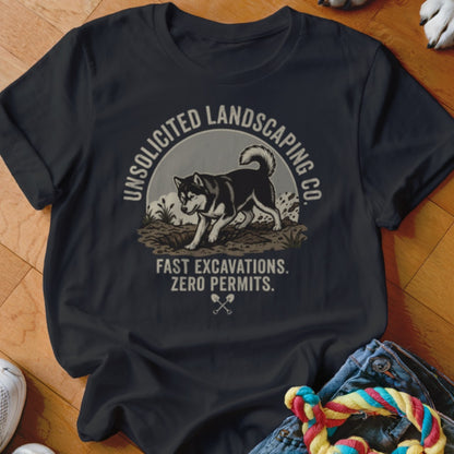 Black t-shirt with graphic of husky digging, text "Unsolicited Landscaping Co. Fast Excavations. Zero Permits."