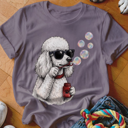 A purple crewneck t-shirt featuring an illustration of a white poodle wearing sunglasses and blowing bubbles.