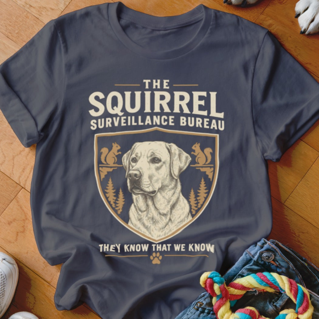 Dark gray t-shirt featuring a graphic with a dog, squirrels, and the text The Squirrel Surveillance Bureau.