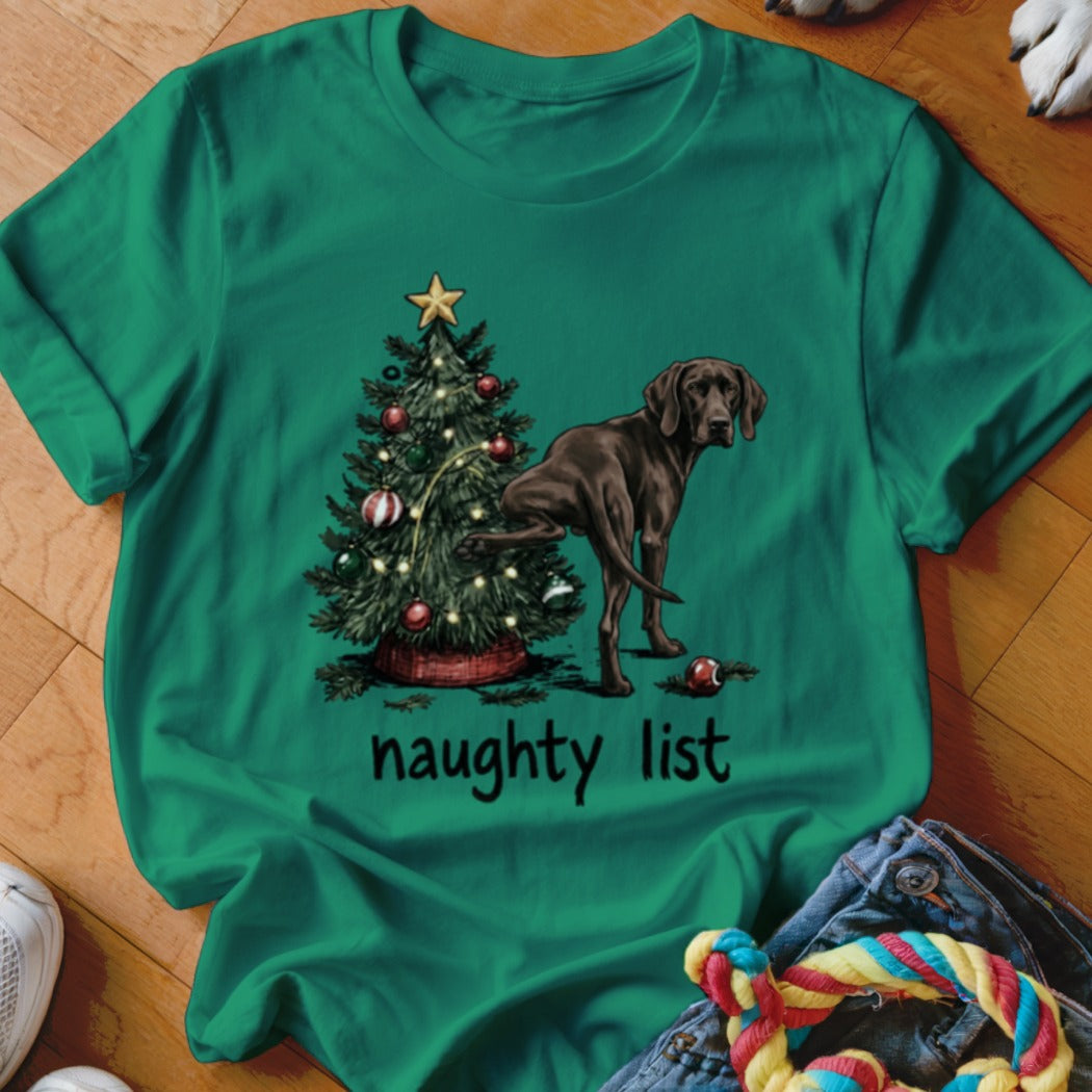 Green t-shirt with a dog near a Christmas tree and "naughty list" text.
