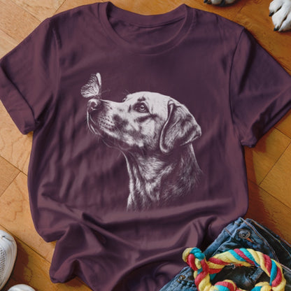 A maroon short-sleeve t-shirt features a white sketch of a dog looking at a butterfly on its nose.