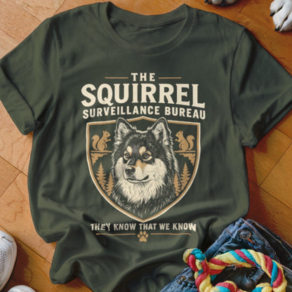 Dark green t-shirt with a graphic of a dog, squirrels, and the text The Squirrel Surveillance Bureau.