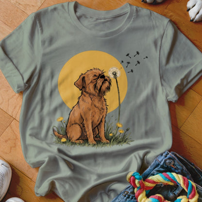 Sage green t-shirt featuring a cartoon illustration of a brown dog blowing dandelion seeds.