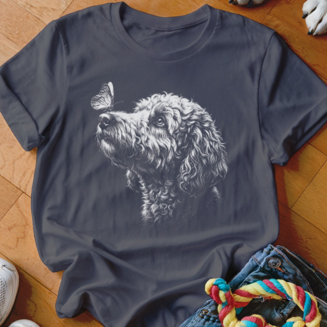 Dark gray crewneck t-shirt featuring a white sketch graphic of a curly-haired dog looking at a butterfly on its nose.