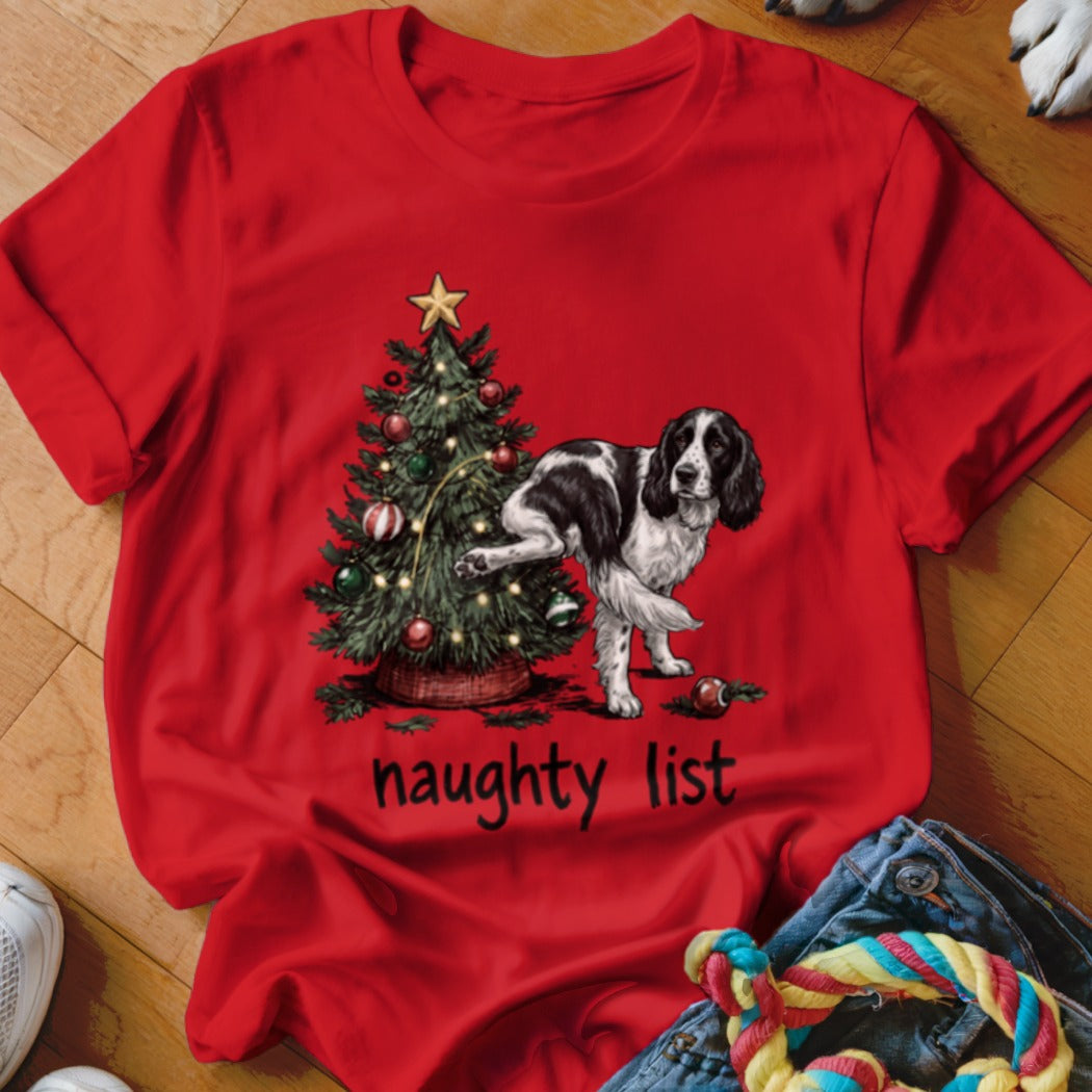Red t-shirt with black and white dog near Christmas tree, "naughty list" text.