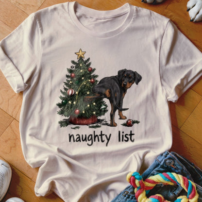 White t-shirt with a Rottweiler relieving itself on a Christmas tree, text reads "naughty list".