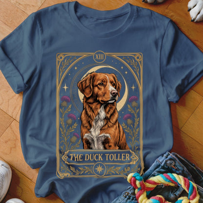 Blue crewneck t-shirt featuring a tarot-style graphic of a Duck Toller dog, moon, and thistles.