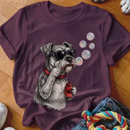 A maroon t-shirt featuring a graphic of a Schnauzer dog wearing sunglasses and blowing bubbles.
