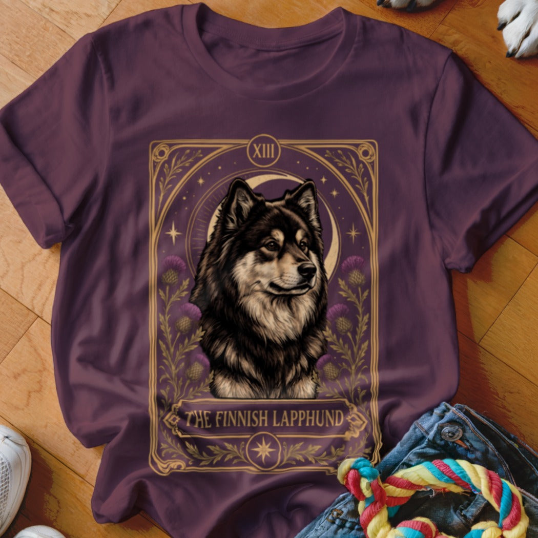 A plum-colored t-shirt features a tarot-style graphic with a Finnish Lapphund, floral details, and the text The Finnish Lapphund.
