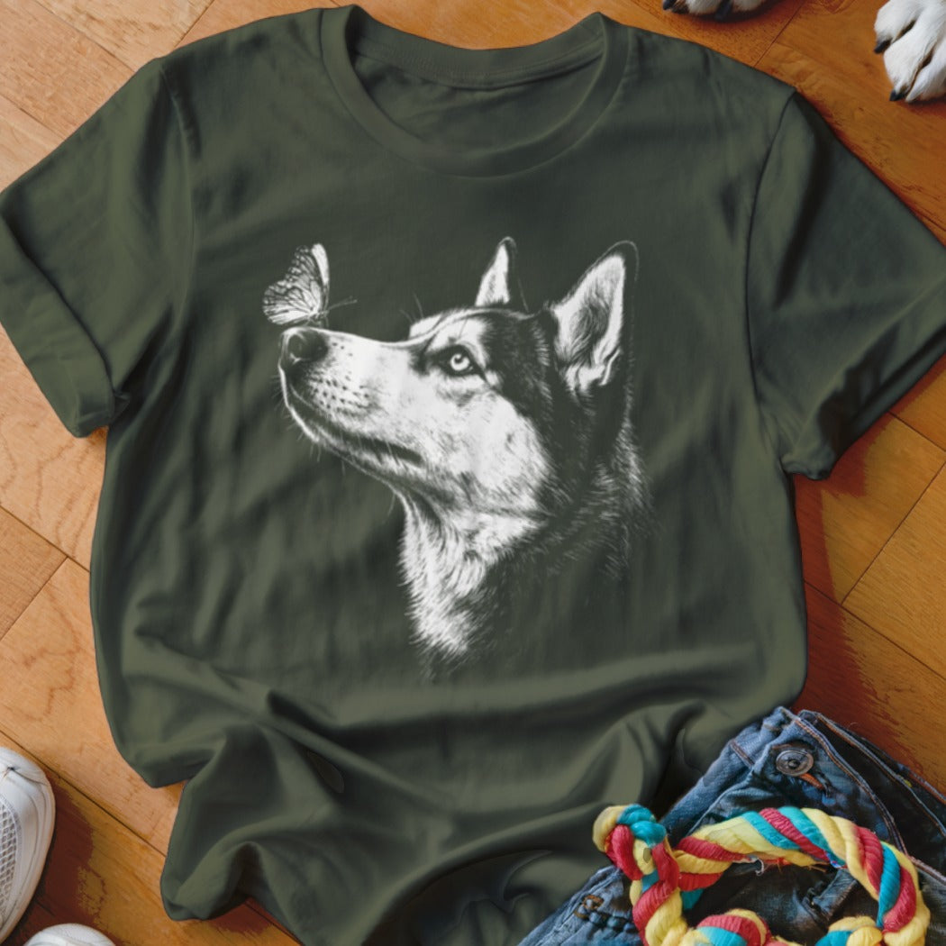 Dark green short-sleeved t-shirt featuring a white graphic of a husky looking at a butterfly on its nose.