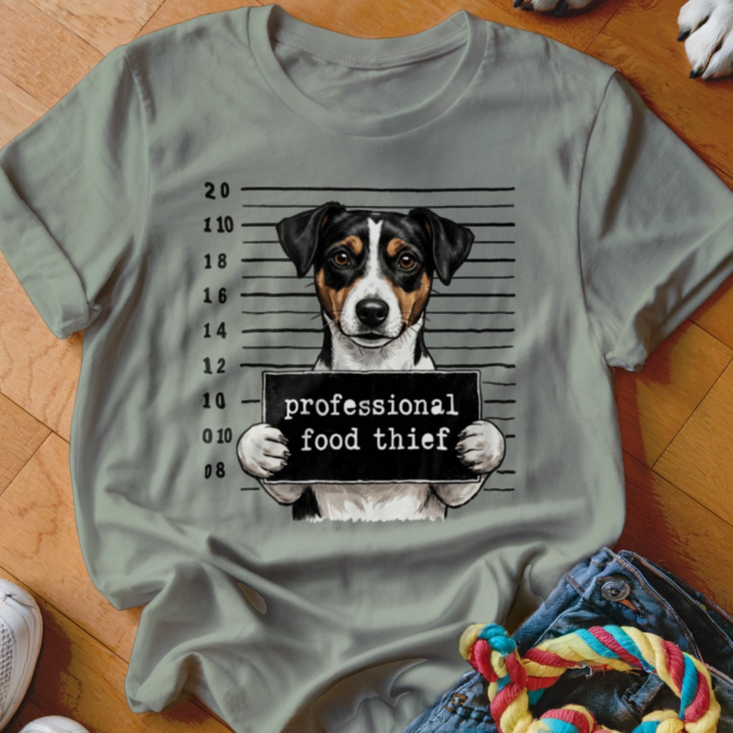 Dog mugshot with "professional food thief" sign on a grey t-shirt.