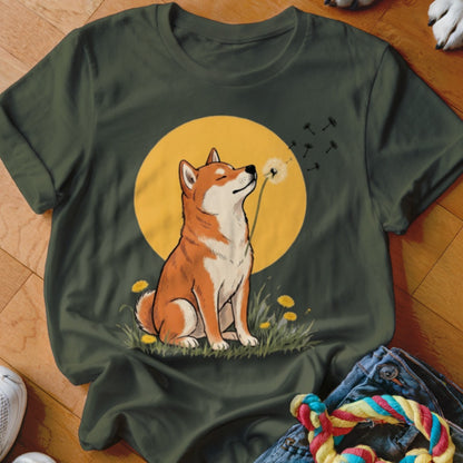 Olive green t-shirt featuring a graphic of a Shiba Inu blowing a dandelion in front of a yellow sun.