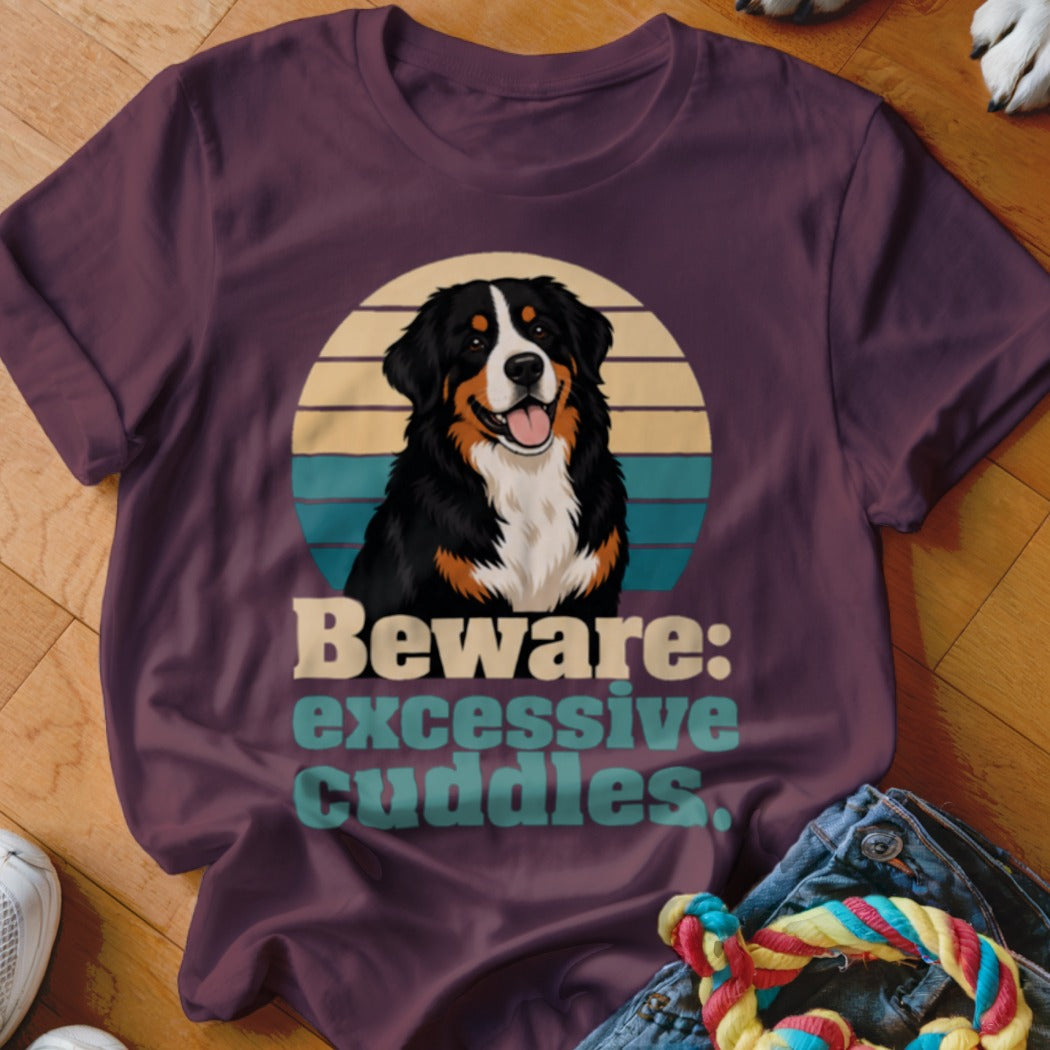 Bernese Mountain Dog graphic with text "Beware: excessive cuddles" on a plum t-shirt.