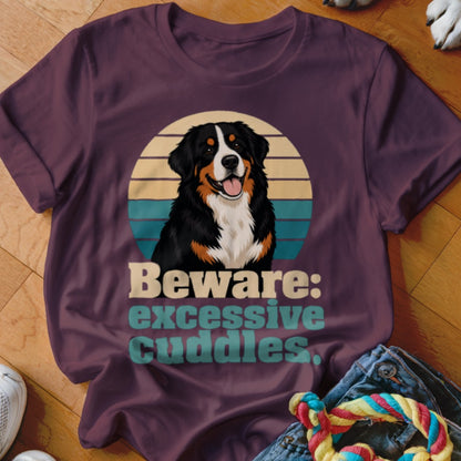 Bernese Mountain Dog graphic with text "Beware: excessive cuddles" on a plum t-shirt.