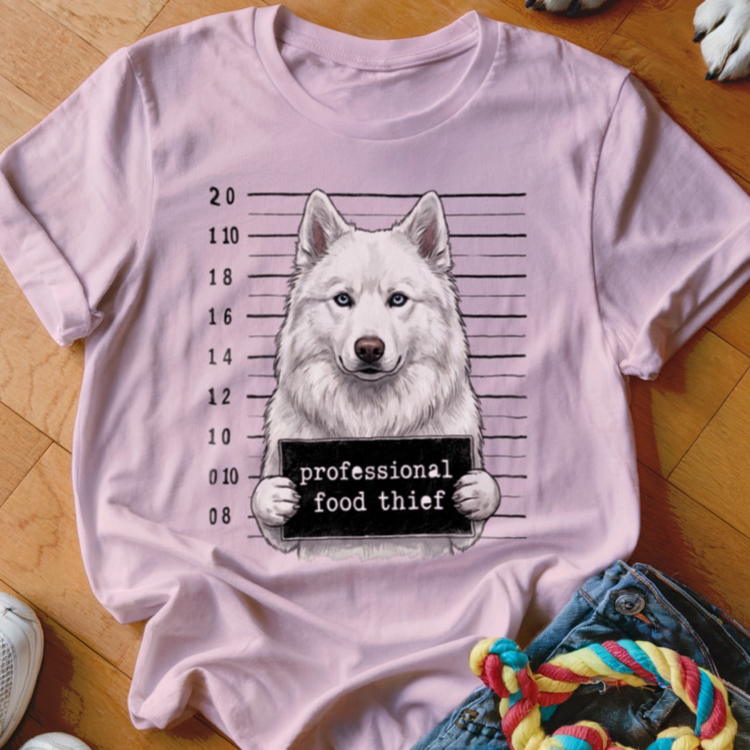 Pink t-shirt with a mugshot of a white husky holding a "professional food thief" sign.