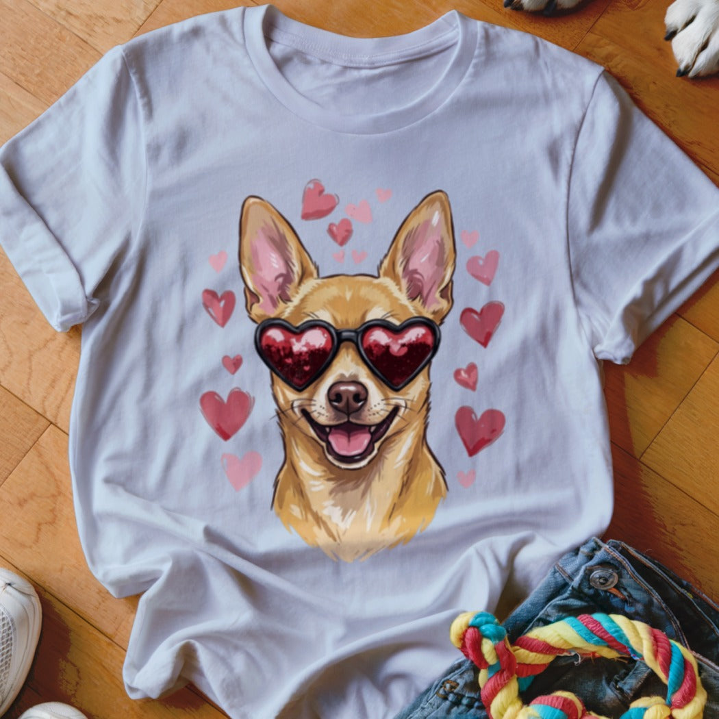 A white short-sleeved t-shirt featuring a smiling tan chihuahua wearing heart-shaped sunglasses surrounded by pink hearts.