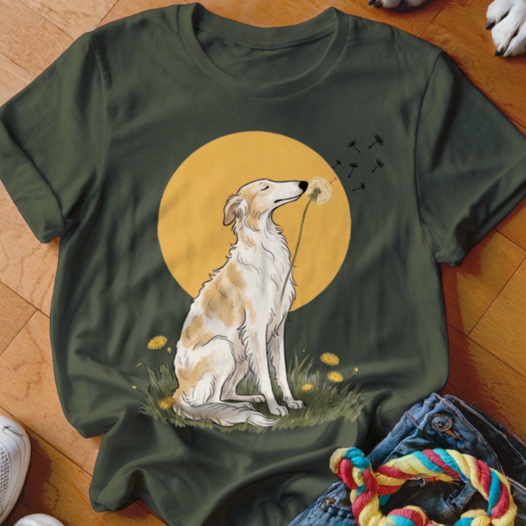 Dark green t-shirt featuring an illustration of a long-snouted dog sitting before a yellow sun and blowing dandelion seeds.