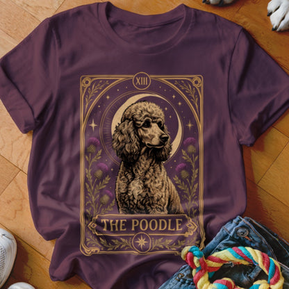 A dark purple t-shirt features a tarot card graphic depicting a poodle, moon, and thistles with the text The Poodle.