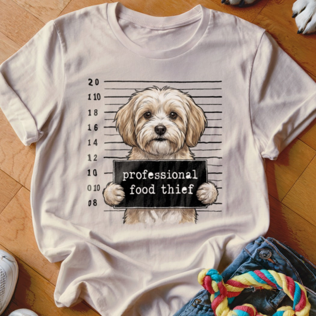 Cream t-shirt with a dog mugshot graphic that reads "professional food thief".